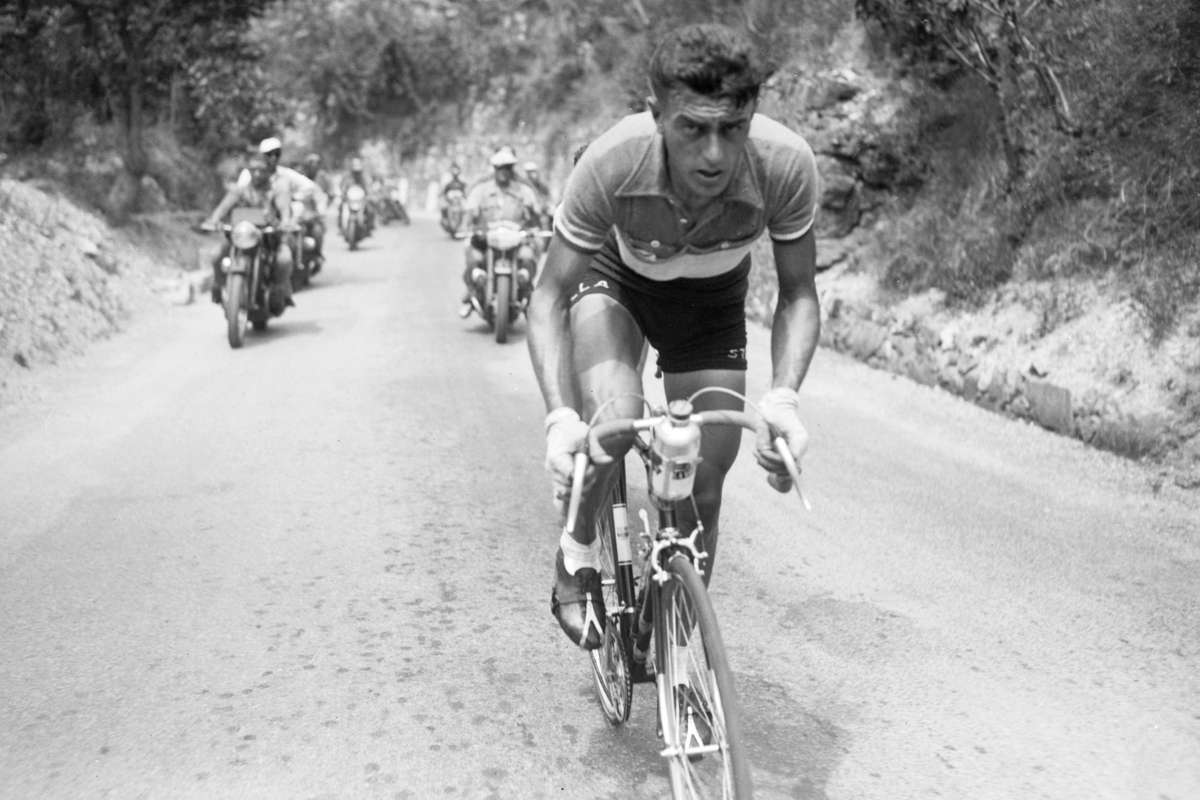 Louison Bobet celebrating on the podium after winning the 1953 Tour de France, wearing the leader's jersey and laurel crown