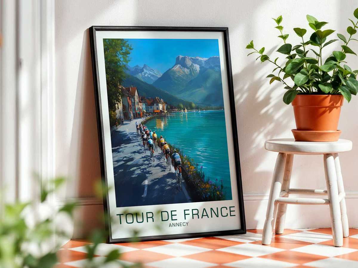 Wide panoramic view of Annecy with alpine ridges framing the horizon and a winding road visible in the valley below