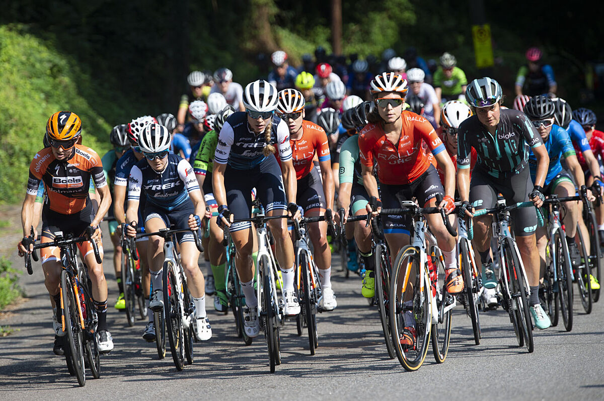 Wide shot of the peloton climbing the Col du Tourmalet, riders grouped tightly with varied bike positions and visible…