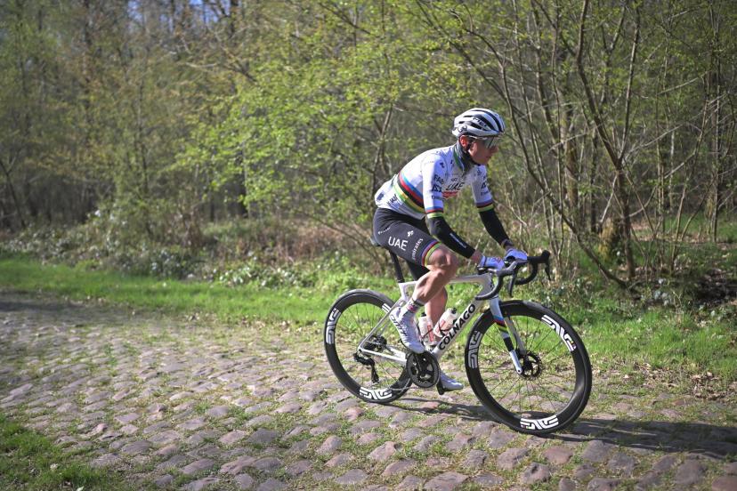 Tadej Pogačar examining the cobbled sector map and shoes before Paris–Roubaix, focused and attentive