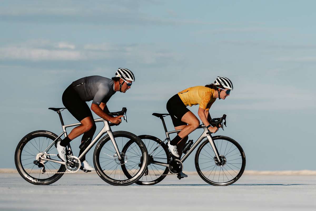 Solo rider on a race racing bike accelerating to join a breakaway while teammates watch behind